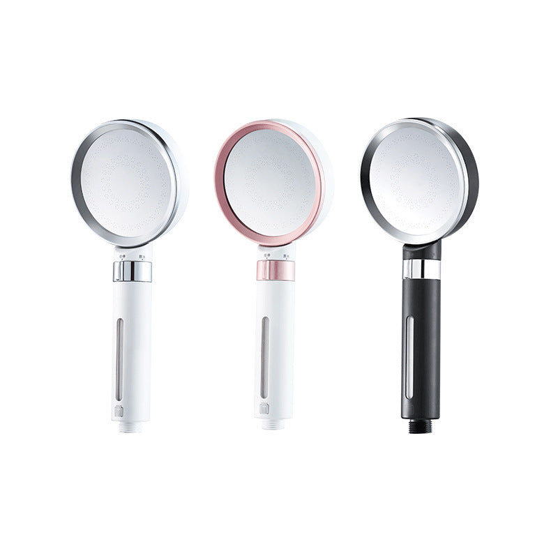 Three handheld shower heads in white, rose gold, and black.